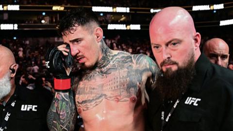 Tom Aspinall holds his right eye after his UFC 321 bout with Cyril Gane