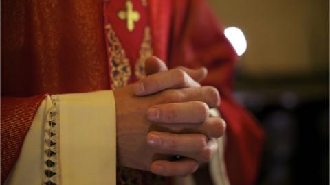 Bishop with clasped hands