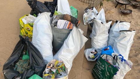 Bagged-up rubbish next to bins