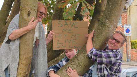 Protestors hugging a tree