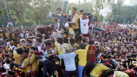 Devotees climb over the Black Nazarene in Manila, Philippines (9 Jan 2019)