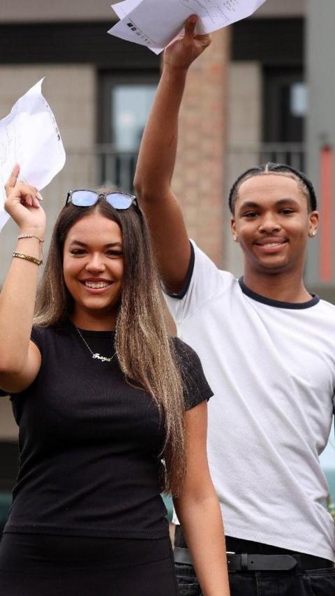 A girl and a boy holding up results