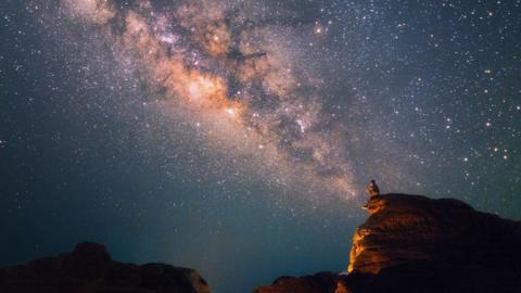 Silhouette of a man looking at the Milky Way Stars shining above the Grand Canyon of Thailand 