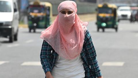 A girl seen with scarf wrapped around her head to sheild herself from the severe heat wave at sector 38 on April 18, 2023 in Noida