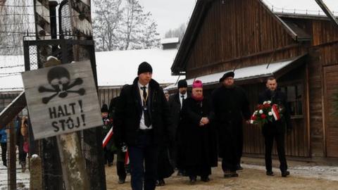 People arrive to lay wreaths at the "death wall" at the former Nazi German concentration and extermination camp Auschwitz