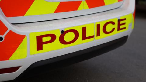 The back of a police car, showing the signage 