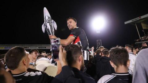 Reece Staunton is carried by fans holding an inflatable fish