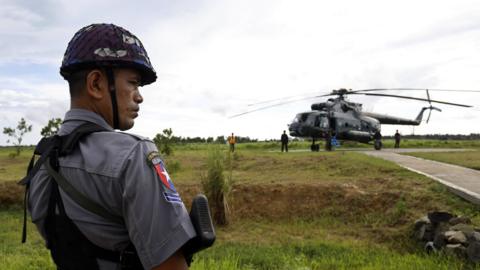 Police stands guard near the military transport helicopter at Maungdaw township in Rakhine State, western Myanmar, 27 September 2017