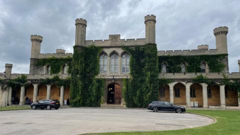 Exterior view of Lincoln Crown Court with ivy climbing up the crenelated walls.