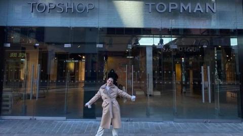 A Topshop employee outside a store