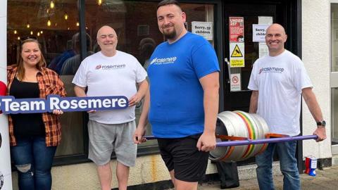 The team outside Lostock Alehouse holding the barrel of beer