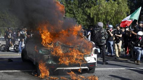 A Waymo self driving car burns as activists protest immigration raids in Los Angele