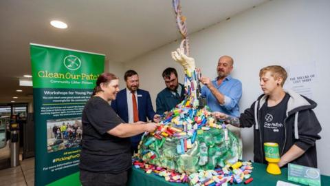 The founders of the litter-picking group and staff of Great Western Railway at Plymouth Railway Station with the sculpture