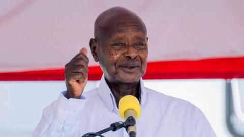 Yoweri Museveni, in white shirt and with fist raised, speaks in Kampala, Uganda, on 5 June 2025