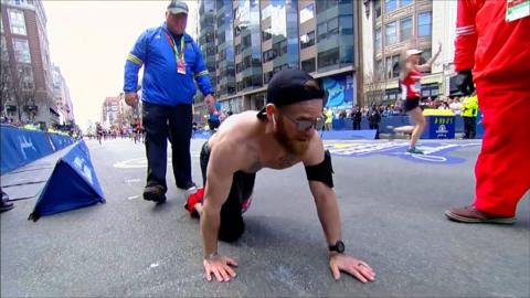 Marine Micah Herndon crawls on street during Boston Marathon