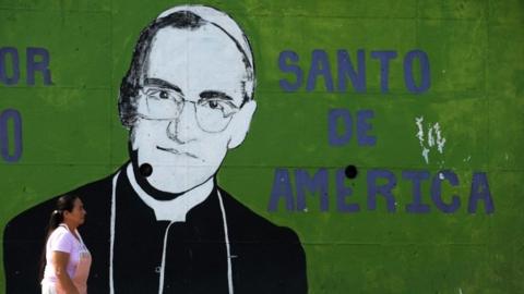 A woman passes by a mural depicting the portrait of Mons. Oscar Arnulfo Romero at La Divina Providencia Hospital in San Salvador on March 17, 2010