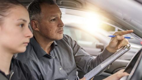 Driving examiner with woman doing test