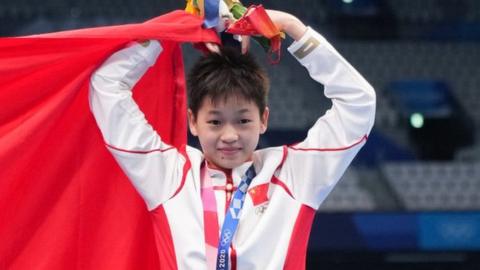 Gold medalist Quan Hongchan of China poses with a Chinese national flag during the medal ceremony for the Women's 10m Platform Final