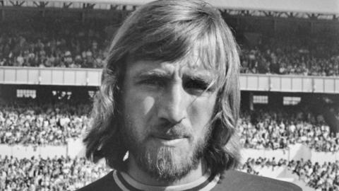A black and white head and shoulders photograph of Billy Bonds in his West Ham kit 
