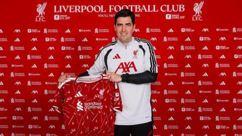 Andoni Iraola holding a Liverpool shirt.
