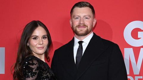 Holly Ramsay and Adam Peaty in front of a red backdrop