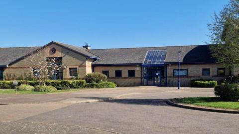 NeneGate School, a single-story pale brick building.