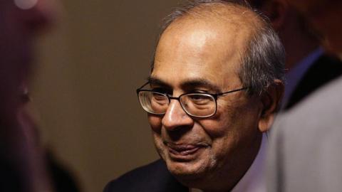 Prakash Hinduja, wearing glasses and listening intently at World Economic Forum (WEF) in Davos years before he was convicted for mistreatment of workers