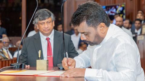 Sri Lanka's new president Anura Kumara Dissanayakespeaks into a microphone alongside men in military clothes after he takes oath as president of Sri Lanka in Colombo, Sri Lanka on September 23, 2024.