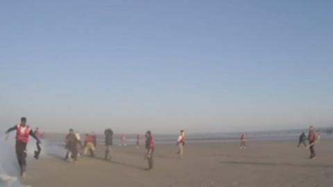 Migrants on the beach in France during an attack on police