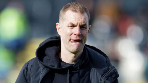 Simon Weaver sticks his tongue out as he concentrates on the touchline