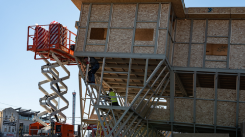 The Upside Down House being constructed with a workman pictured inside the structure.