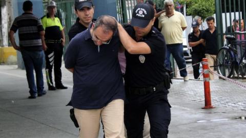 Admiral Atilla Demirhan, front, and a group of military personnel are detained in Mersin, Turkey, Tuesday, July 19, 2016.