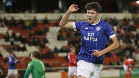 Rubin Colwill runs with one arm bent in the air and his mouth open during Cardiff's match with Barnsley