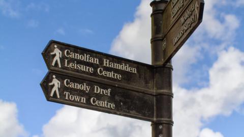 Multi directional Welsh sign for Leisure Centre and Town Centre