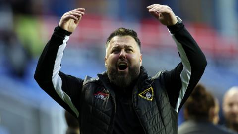 Harborough Town boss Mitch Austin with his hands up in celebration