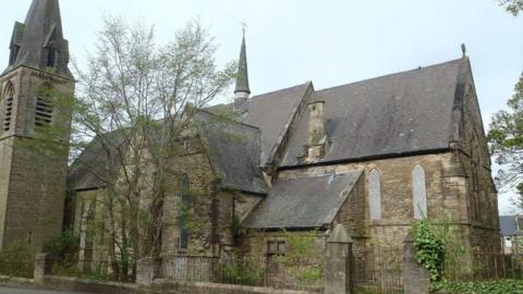 A view of St Aidan's Church in Blackhill, near Consett, County Durham. The church's window's are boarded up, and tiles are visibly missing from the roof. 