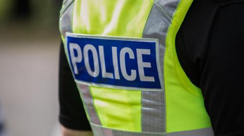A stock photo of a police officer wearing a high vis police vest