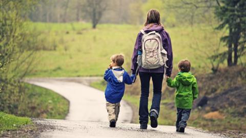 Two children walking with parent