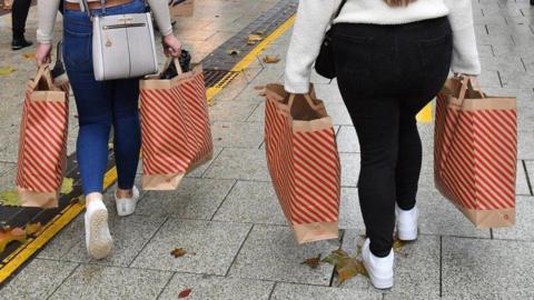 shoppers carrying bags on high street