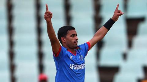 Leg-spinner Shafiqullah Ghafari raises his arms in celebration after taking a wicket for Afghanistan