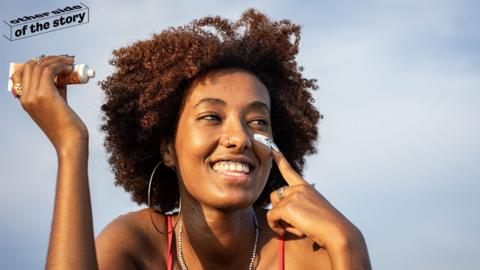 Woman applying sunscreen to her face