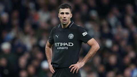 Rodri stands with his hands on his hips during Manchester City's game at Tottenham