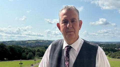 Edwin Poots in white shirt with grey waistcoast and tie