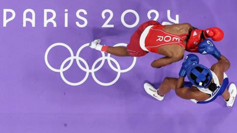 France's Davina Michel of France in blue goes up against Cindy Ngamba of the Refugee Olympic team in red at the Paris Olympics