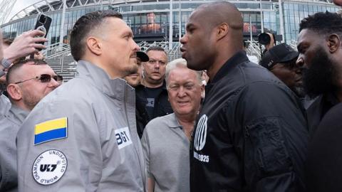Oleksandr Usyk stares at Daniel Dubois who is shouting at him during a face-off