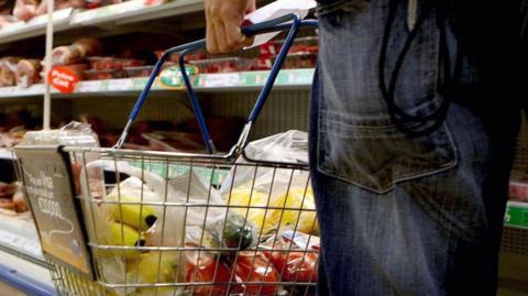 Man with shopping basket in supermarket