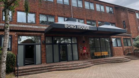 A three-storey building which says "Bond House" on the front of it.