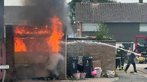 Fire crews spray water onto a fire