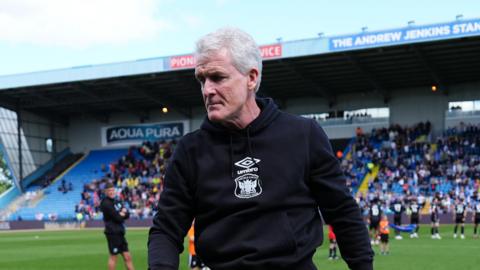 Mark Hughes walking off the pitch at the end of a Carlisle match at Brunton Park