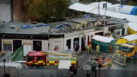 Rescuers lift the police helicopter wreckage from the roof of the The Clutha Pub on December 2, 2013